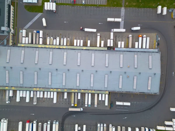 Mal depolama gecesinin hava görüntüsü. Lojistik dağıtım, sanayi bölgesinin merkezi yukarıdan. Lojistik merkezde yüklenen kamyonların hava görüntüsü. İnsansız hava aracından görüntüle.