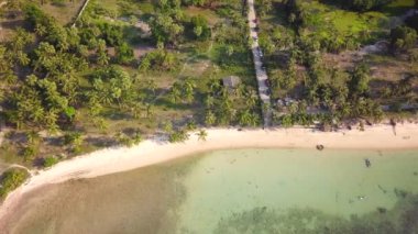 4K Aerial Front View of Surin Beach, Phuket. Beach, sea, sand and palms. Drone view of a beautiful white tropical sand beach on a summer day. Top view empty and clean beach. Phuket, Thailand.