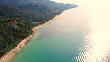 4K Aerial Front View of Surin Beach, Phuket. Beach, sea, sand and palms. Drone view of a beautiful white tropical sand beach on a summer day. Top view empty and clean beach. Phuket, Thailand.