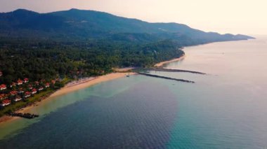 4K Aerial Front View of Surin Beach, Phuket. Beach, sea, sand and palms. Drone view of a beautiful white tropical sand beach on a summer day. Top view empty and clean beach. Phuket, Thailand.