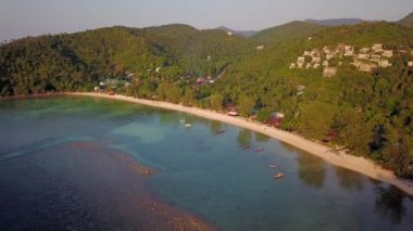 4k Aerial Drone Push Forward Shot of Salad Beach on Koh Phangan in Thailand with Fishing Boats, Teal Water, Coral, and Green Jungles