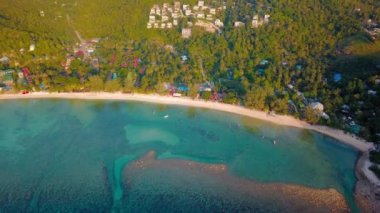 4k Aerial Drone Push Forward Shot of Salad Beach on Koh Phangan in Thailand with Fishing Boats, Teal Water, Coral, and Green Jungles