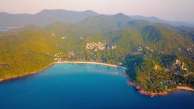 4k Aerial Drone Push Forward Shot of Salad Beach on Koh Phangan in Thailand with Fishing Boats, Teal Water, Coral, and Green Jungles