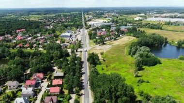 Semi-trailer trucks stand at the ramps of warehouse in the logistics park with loading hub and wait for load and unload goods at sunset. Aerial view