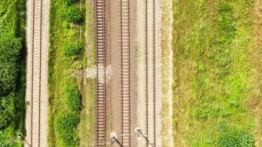 Railway cargo train wagon rides on railroad. Transportation and delivery of cargo in containers. Aerial view over train riding near river and coal power plant.