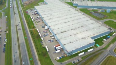 Depolar, otoyola yakın büyük lojistik merkezleri, çok sayıda kargo karavanı ve konteynır manzarası, uluslararası kargo taşımacılığı, hava manzarası.