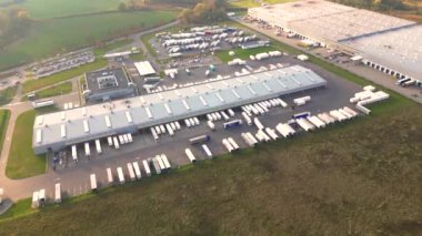 Malzeme deposunun havadan görüntüsü. Sanayi bölgesindeki lojistik merkezi yukarıdan. Lojistik merkezde yüklenen kamyonların hava görüntüsü. İnsansız hava aracından görüntüle.