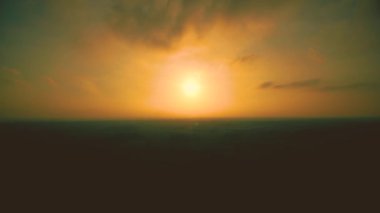 Sarı Gökte Günbatımı. Zaman ayarlı. Büyük parlak sarı güneş batıyor. Gökyüzünün muhteşem manzarası ve ufuktaki orman silueti. Batan güneşin inanılmaz renkleri. Canlı bir renk. Zaman Süreleri