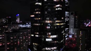 Aerial view of office windows in a modern skyscraper in the city center at night. Close-up of windows of offices in a skyscraper, business center