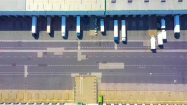 Depo rampalarında durmakta olan kargo römorklu bir tırın hava görüntüsü. Yükleme merkezli büyük lojistik parkındaki malları yüklemek / boşaltmak için.