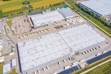 Malzeme deposunun havadan görüntüsü. Sanayi bölgesindeki lojistik merkezi yukarıdan. Lojistik merkez stok fotoğrafına yüklenen kamyonların hava görüntüsü