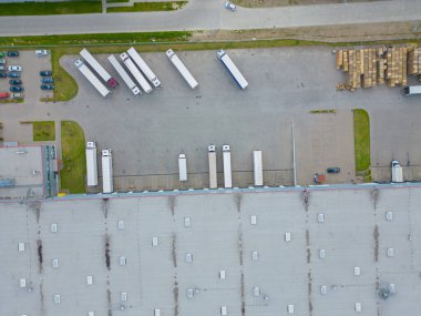 Malzeme deposunun havadan görüntüsü. Sanayi bölgesindeki lojistik merkezi yukarıdan. Lojistik merkezde yüklenen kamyonların hava görüntüsü