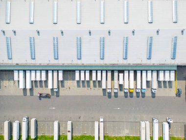 Depoyla birlikte lojistik parkı. Yarı karavan kamyonları araba parkında duruyor ve yükleme ve boşaltma için rampalarda bekliyorlar. Hava görünümü