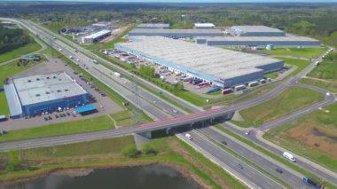 Malzeme deposunun havadan görüntüsü. Sanayi bölgesindeki lojistik merkezi yukarıdan. Lojistik merkezde yüklenen kamyonların hava görüntüsü. İnsansız hava aracından görüntüle.