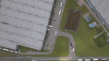 Malzeme deposunun havadan görüntüsü. Sanayi bölgesindeki lojistik merkezi yukarıdan. Lojistik merkezde yüklenen kamyonların hava görüntüsü. İnsansız hava aracından görüntüle.