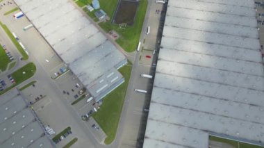 Malzeme deposunun havadan görüntüsü. Sanayi bölgesindeki lojistik merkezi yukarıdan. Lojistik merkezde yüklenen kamyonların hava görüntüsü. İnsansız hava aracından görüntüle.