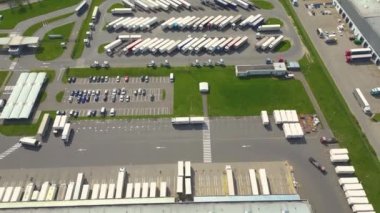 Malzeme deposunun havadan görüntüsü. Sanayi bölgesindeki lojistik merkezi yukarıdan. Lojistik merkezde yüklenen kamyonların hava görüntüsü. İnsansız hava aracından görüntüle.