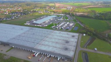 Malzeme deposunun havadan görüntüsü. Sanayi bölgesindeki lojistik merkezi yukarıdan. Lojistik merkezde yüklenen kamyonların hava görüntüsü. İnsansız hava aracından görüntüle.