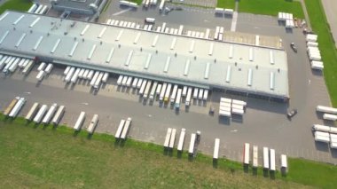 Malzeme deposunun havadan görüntüsü. Sanayi bölgesindeki lojistik merkezi yukarıdan. Lojistik merkezde yüklenen kamyonların hava görüntüsü