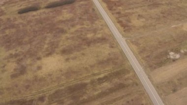 Yeşil yaprak döken bir ormanda, manzaralı bir yolda uçan bir dronun hava görüntüsü. Bir kır yolu boyunca arabayla seyahat etmek. - Evet. Yüksek kalite 4k görüntü