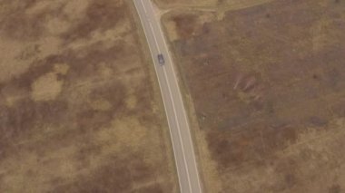 Yeşil yaprak döken bir ormanda, manzaralı bir yolda uçan bir dronun hava görüntüsü. Bir kır yolu boyunca arabayla seyahat etmek. - Evet. Yüksek kalite 4k görüntü