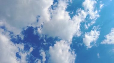 Gökyüzü zamanı hızlandırılmış bulutlar ve mavi güneşli gökyüzü, mavi gökyüzü üzerindeki beyaz bulutlar güneş ışınları, hava manzarası, bulutların hareket zamanı, doğa mavi gökyüzü açık hava. 4K.