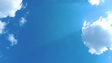Gökyüzü zamanı hızlandırılmış bulutlar ve mavi güneşli gökyüzü, mavi gökyüzü üzerindeki beyaz bulutlar güneş ışınları, hava manzarası, bulutların hareket zamanı, doğa mavi gökyüzü açık hava. 4K.