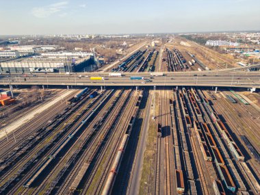 Kargo trenleri yakın plan. Tren istasyonundaki renkli yük trenlerinin hava manzarası. Demiryolunda malları olan vagonlar. Ağır endüstri. Trenli endüstriyel kavramsal sahne. Uçan İHA 'nın üst görüntüsü