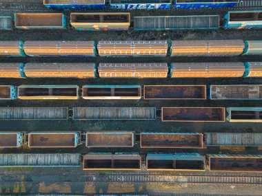 Kargo trenleri yakın plan. Tren istasyonundaki renkli yük trenlerinin hava manzarası. Demiryolunda malları olan vagonlar. Ağır endüstri. Trenli endüstriyel kavramsal sahne. Uçan İHA 'nın üst görüntüsü