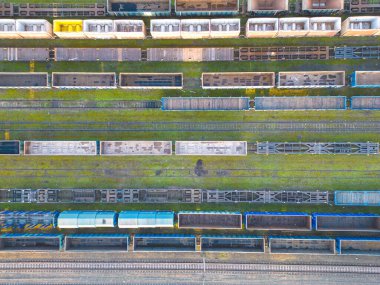 Kargo trenleri yakın plan. Tren istasyonundaki renkli yük trenlerinin hava manzarası. Demiryolunda malları olan vagonlar. Ağır endüstri. Trenli endüstriyel kavramsal sahne. Uçan İHA 'nın üst görüntüsü