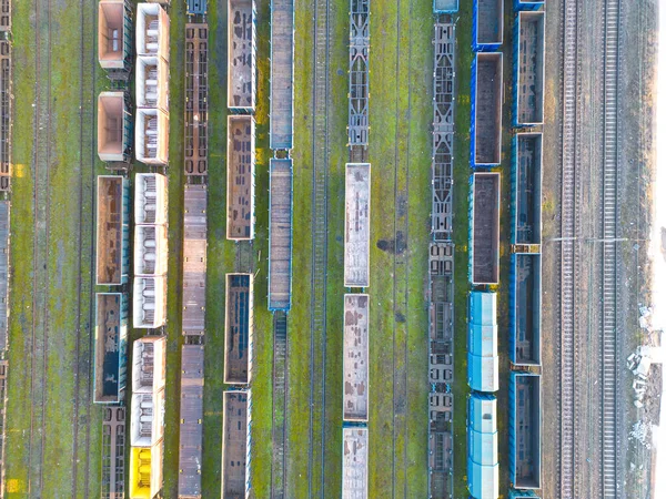 貨物列車が接近中 鉄道駅でカラフルな貨物列車の空中ビュー 貨物を積んだワゴンだ 重工業だ 電車と産業概念のシーン 飛行ドローンからのトップビュー — ストック写真
