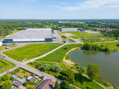 Dağıtım merkezinin hava görüntüsü, endüstriyel lojistik bölgesinin İHA fotoğrafı, modern teknoloji ve robotlarla dolu yeni süper modern lojistik merkezi, yeşil enerji üretimi için çatı güneş enerjisi santrali.