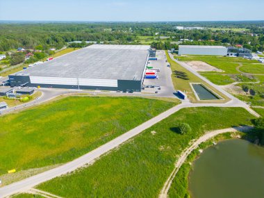 Dağıtım merkezinin hava görüntüsü, endüstriyel lojistik bölgesinin İHA fotoğrafı, modern teknoloji ve robotlarla dolu yeni süper modern lojistik merkezi, yeşil enerji üretimi için çatı güneş enerjisi santrali.