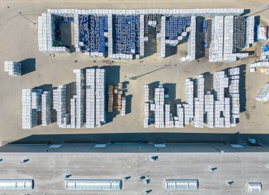 Malzeme deposunun havadan görüntüsü. Sanayi bölgesindeki lojistik merkezi yukarıdan. Lojistik merkezde yüklenen kamyonların hava görüntüsü. İnsansız hava aracından görüntüle.