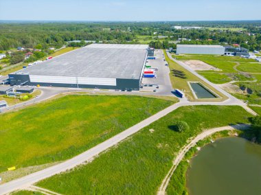 Dağıtım merkezinin hava görüntüsü, endüstriyel lojistik bölgesinin İHA fotoğrafı, modern teknoloji ve robotlarla dolu yeni süper modern lojistik merkezi, yeşil enerji üretimi için çatı güneş enerjisi santrali.