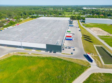 Malzeme deposunun havadan görüntüsü. Sanayi bölgesindeki lojistik merkezi yukarıdan. Lojistik merkezde yüklenen kamyonların hava görüntüsü. İnsansız hava aracından görüntüle.