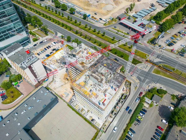 new residential district under construction. construction site with yellow tower cranes and machinery. aerial top view. City center
