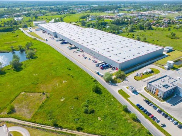 stock image Aerial view of distribution center, drone photo of industrial logistics zone,new super modern logistics center full of modern technology and robotics,roof solar power plant for green energy production