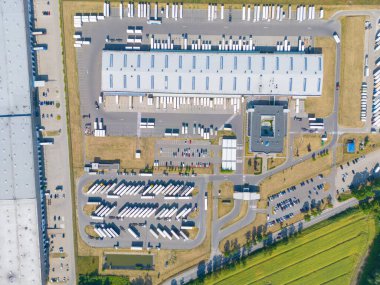 Malzeme deposunun havadan görüntüsü. Sanayi bölgesindeki lojistik merkezi yukarıdan. Lojistik merkezde yüklenen kamyonların hava görüntüsü