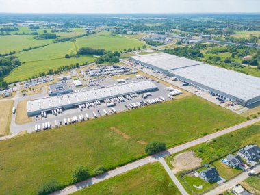 Malzeme deposunun havadan görüntüsü. Sanayi bölgesindeki lojistik merkezi yukarıdan. Lojistik merkezde yüklenen kamyonların hava görüntüsü. İnsansız hava aracından görüntüle.