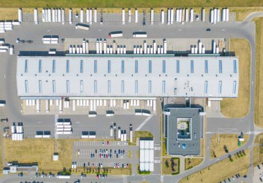 Malzeme deposunun havadan görüntüsü. Sanayi bölgesindeki lojistik merkezi yukarıdan. Lojistik merkezde yüklenen kamyonların hava görüntüsü. İnsansız hava aracından görüntüle.