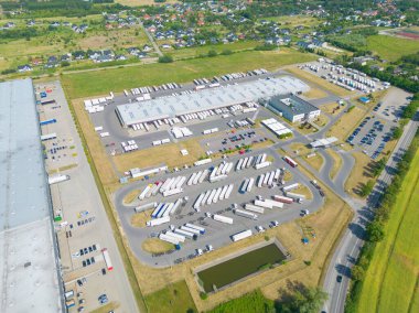 Malzeme deposunun havadan görüntüsü. Sanayi bölgesindeki lojistik merkezi yukarıdan. Lojistik merkezde yüklenen kamyonların hava görüntüsü. İnsansız hava aracından görüntüle.