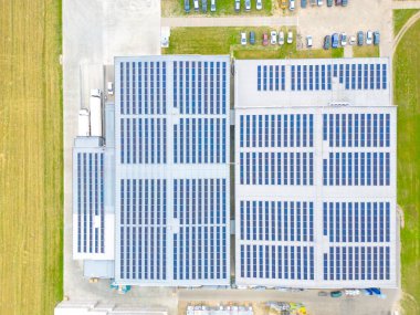 Çatıda güneş panelleri olan modern deponun hava görüntüsü. Endüstriyel şehir bölgesindeki lojistik merkezi İHA 'nın gözünden. Arkaplan dokusu kavramı.