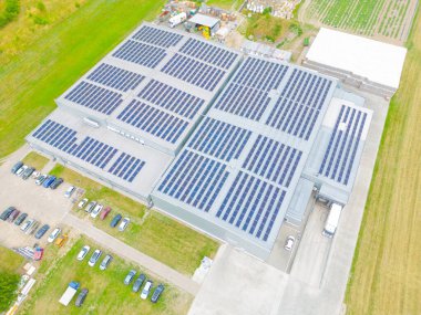 Çatıda güneş panelleri olan modern deponun hava görüntüsü. Endüstriyel şehir bölgesindeki lojistik merkezi İHA 'nın gözünden. Arkaplan dokusu kavramı.