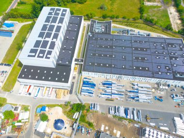 Çatıda güneş panelleri olan modern deponun hava görüntüsü. Endüstriyel şehir bölgesindeki lojistik merkezi İHA 'nın gözünden. Arkaplan dokusu kavramı.