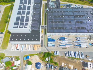 Çatıda güneş panelleri olan modern deponun hava görüntüsü. Endüstriyel şehir bölgesindeki lojistik merkezi İHA 'nın gözünden. Arkaplan dokusu kavramı.