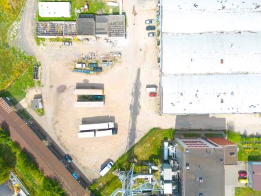 Gün batımında yükleme / boşaltma malları için rampalarda bekleyen depo, merkez ve kargo karavanıyla lojistik parkının hava görüntüsü.