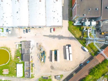 Gün batımında yükleme / boşaltma malları için rampalarda bekleyen depo, merkez ve kargo karavanıyla lojistik parkının hava görüntüsü.