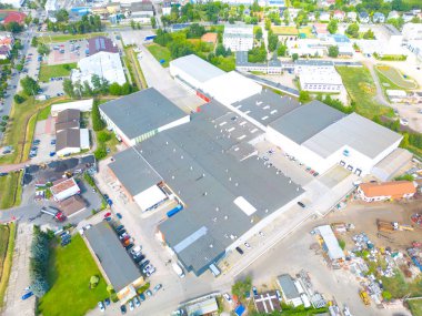 Gün batımında yükleme / boşaltma malları için rampalarda bekleyen depo, merkez ve kargo karavanıyla lojistik parkının hava görüntüsü.