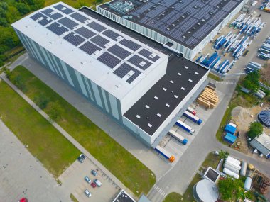 Dağıtım merkezinin hava görüntüsü, endüstriyel lojistik bölgesinin İHA fotoğrafı, modern teknoloji ve robotlarla dolu yeni süper modern lojistik merkezi, yeşil enerji üretimi için çatı güneş enerjisi santrali.